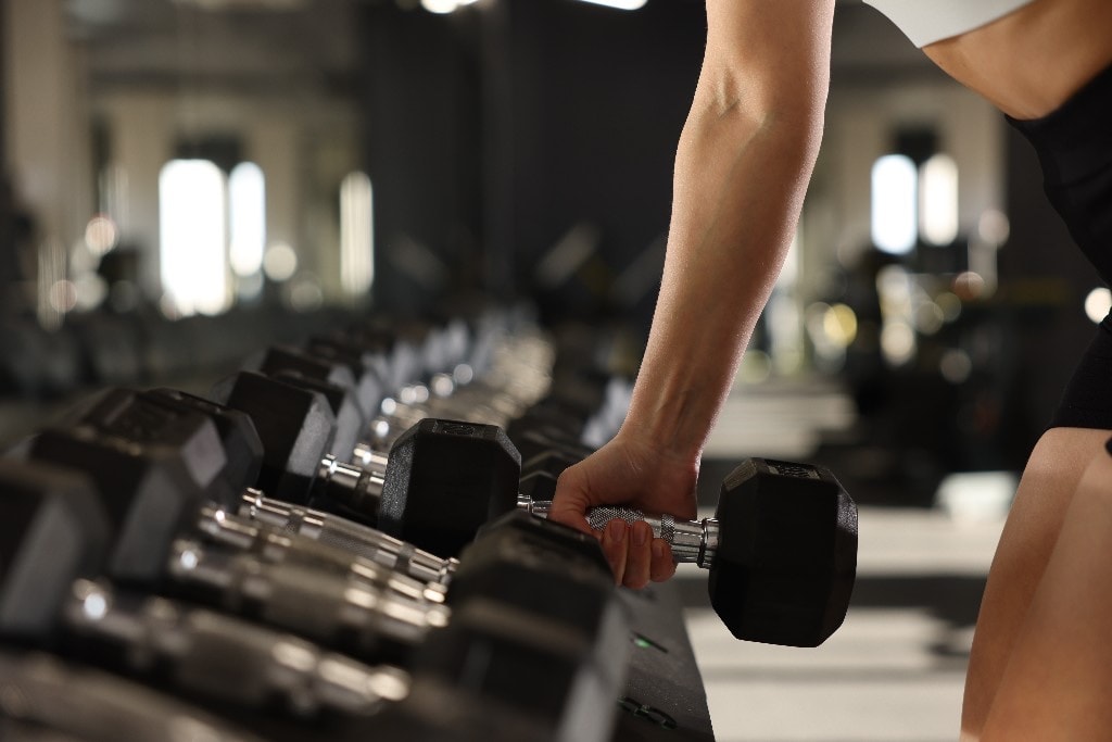 Reaching for a dumbbell on the rack at NoosaFit 24-7
